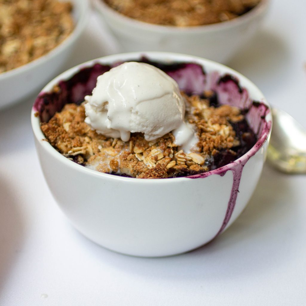 An individual portion of apple and blueberry crisp